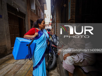 A Nepali health worker is inquiring with an elderly member of a family to ensure the children below 5 years are being administered with 'OPV...