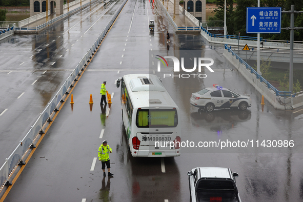 Police officers are on duty on a flooded road after heavy rain in Sanmenxia, China, on July 24, 2024. 