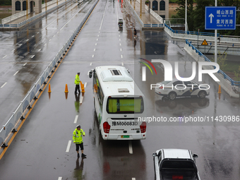 Police officers are on duty on a flooded road after heavy rain in Sanmenxia, China, on July 24, 2024. (