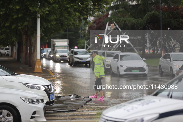 Vehicles are running on a flooded road after heavy rain in Sanmenxia, Henan province, China, on July 24, 2024. 