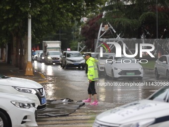 Vehicles are running on a flooded road after heavy rain in Sanmenxia, Henan province, China, on July 24, 2024. (