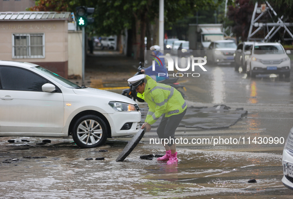 A police officer is on duty on a flooded road after heavy rain in Sanmenxia, Henan province, China, on July 24, 2024. 