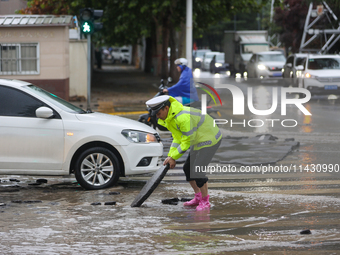 A police officer is on duty on a flooded road after heavy rain in Sanmenxia, Henan province, China, on July 24, 2024. (