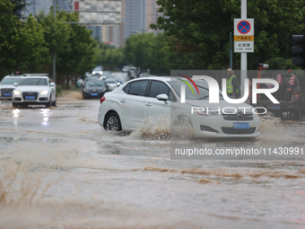 Vehicles are running on a flooded road after heavy rain in Sanmenxia, Henan province, China, on July 24, 2024. (