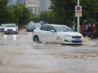 Vehicles are running on a flooded road after heavy rain in Sanmenxia, Henan province, China, on July 24, 2024. (