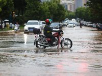 Vehicles are running on a flooded road after heavy rain in Sanmenxia, Henan province, China, on July 24, 2024. (