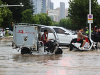 Vehicles are running on a flooded road after heavy rain in Sanmenxia, Henan province, China, on July 24, 2024. (