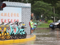 A child is walking on a flooded road after heavy rain in Sanmenxia, China, on July 24, 2024. (