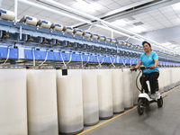 A worker is carrying out an inspection at a textile workshop in Aksu prefecture, Northwest China's Xinjiang Uygur autonomous region, on July...