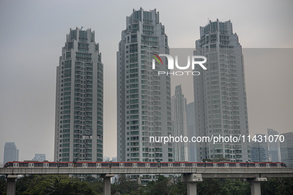 Cars of the LRT train are passing through the business district of Jakarta, Indonesia, on July 24, 2024. 