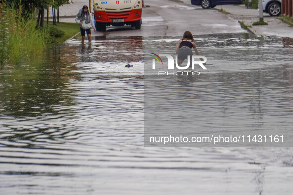 A street is flooding after a strong storm and downpour in Gdansk, Poland, on July 24, 2024. Heavy downpours and strong storms are causing nu...