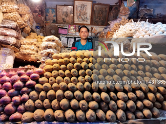 A person is selling potatoes, onions, and gingers inside a market in Kolkata, India, on July 24, 2024. (