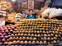 A person is selling potatoes, onions, and gingers inside a market in Kolkata, India, on July 24, 2024. (