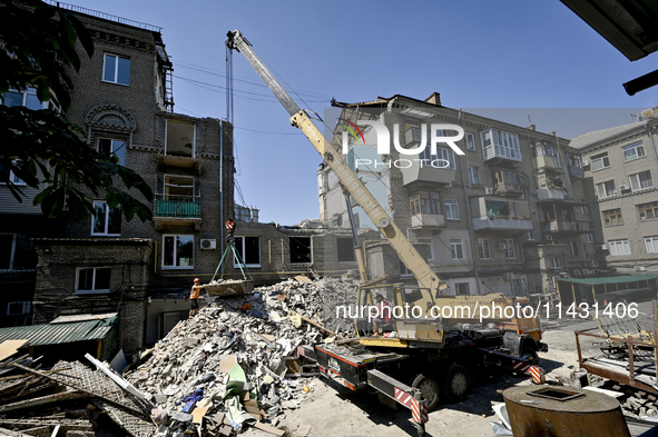 Workers are dismantling damaged structures as one of the sections of the five-storey apartment building at 44 Sobornyi Avenue that was destr...