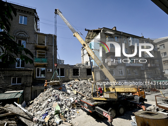 Workers are dismantling damaged structures as one of the sections of the five-storey apartment building at 44 Sobornyi Avenue that was destr...