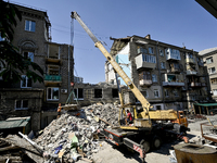 Workers are dismantling damaged structures as one of the sections of the five-storey apartment building at 44 Sobornyi Avenue that was destr...