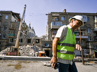 Workers are dismantling damaged structures as one of the sections of the five-storey apartment building at 44 Sobornyi Avenue that was destr...