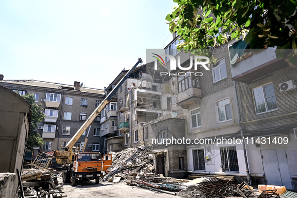 Workers are dismantling damaged structures as one of the sections of the five-storey apartment building at 44 Sobornyi Avenue that was destr...