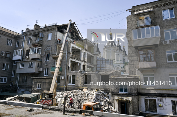 Workers are dismantling damaged structures as one of the sections of the five-storey apartment building at 44 Sobornyi Avenue that was destr...