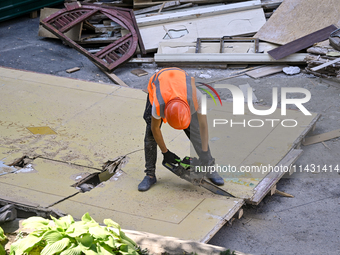 A builder is working to rebuild one of the sections of the five-storey apartment building at 44 Sobornyi Avenue that was destroyed by the Ru...