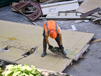 A builder is working to rebuild one of the sections of the five-storey apartment building at 44 Sobornyi Avenue that was destroyed by the Ru...