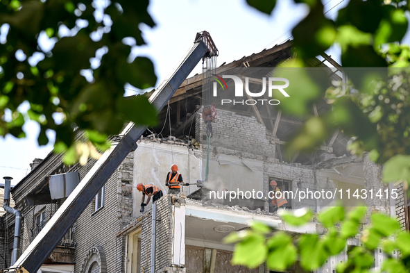 Workers are dismantling damaged structures as one of the sections of the five-storey apartment building at 44 Sobornyi Avenue that was destr...