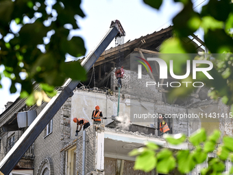 Workers are dismantling damaged structures as one of the sections of the five-storey apartment building at 44 Sobornyi Avenue that was destr...