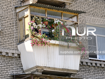 Flower pots are decorating a balcony of the five-storey apartment building at 44 Sobornyi Avenue as one of its sections is destroyed by the...