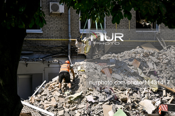 A worker is climbing a pile of rubble as one of the sections of the five-storey apartment building at 44 Sobornyi Avenue that was destroyed...