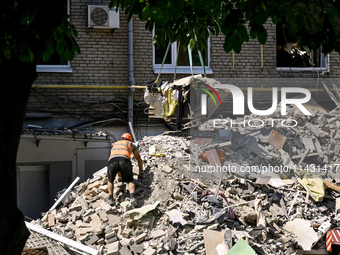 A worker is climbing a pile of rubble as one of the sections of the five-storey apartment building at 44 Sobornyi Avenue that was destroyed...