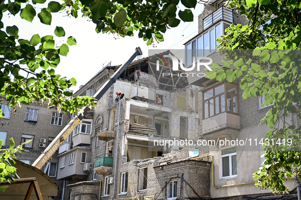 Workers are dismantling damaged structures as one of the sections of the five-storey apartment building at 44 Sobornyi Avenue that was destr...