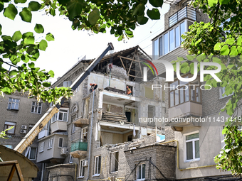 Workers are dismantling damaged structures as one of the sections of the five-storey apartment building at 44 Sobornyi Avenue that was destr...