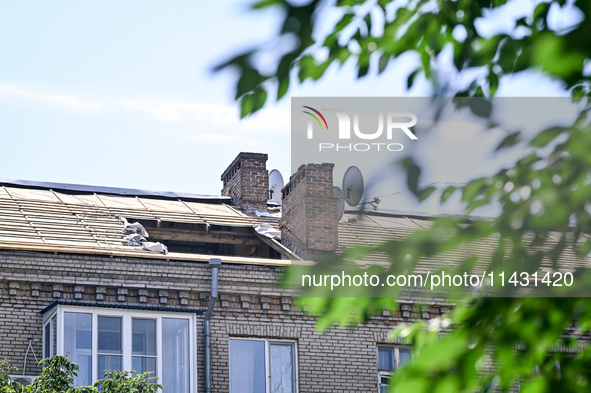 The damaged roof of the five-storey apartment building at 44 Sobornyi Avenue is being seen as one of its sections is being destroyed by the...