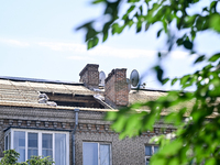 The damaged roof of the five-storey apartment building at 44 Sobornyi Avenue is being seen as one of its sections is being destroyed by the...