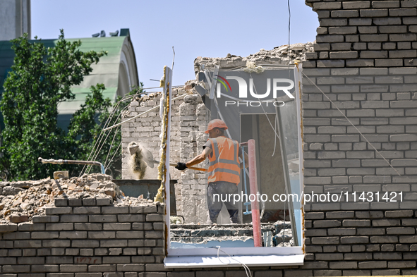 A builder is working to rebuild one of the sections of the five-storey apartment building at 44 Sobornyi Avenue that was destroyed by the Ru...