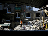 Workers are dismantling damaged structures as one of the sections of the five-storey apartment building at 44 Sobornyi Avenue that was destr...