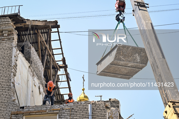 Workers are dismantling damaged structures as one of the sections of the five-storey apartment building at 44 Sobornyi Avenue that was destr...