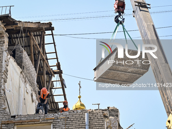 Workers are dismantling damaged structures as one of the sections of the five-storey apartment building at 44 Sobornyi Avenue that was destr...