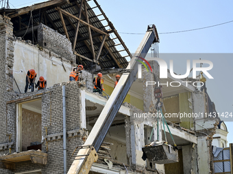 Workers are dismantling damaged structures as one of the sections of the five-storey apartment building at 44 Sobornyi Avenue that was destr...