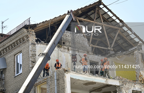 Workers are dismantling damaged structures as one of the sections of the five-storey apartment building at 44 Sobornyi Avenue that was destr...