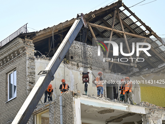 Workers are dismantling damaged structures as one of the sections of the five-storey apartment building at 44 Sobornyi Avenue that was destr...