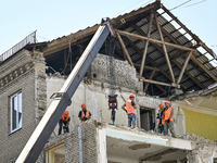 Workers are dismantling damaged structures as one of the sections of the five-storey apartment building at 44 Sobornyi Avenue that was destr...