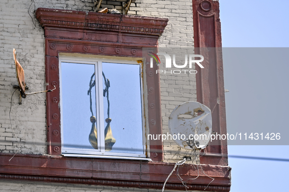 Damaged satellite dishes are being seen on the five-storey apartment building at 44 Sobornyi Avenue as one of its sections is being destroye...