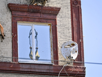 Damaged satellite dishes are being seen on the five-storey apartment building at 44 Sobornyi Avenue as one of its sections is being destroye...