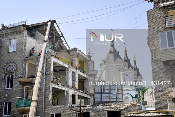 Workers are dismantling damaged structures as one of the sections of the five-storey apartment building at 44 Sobornyi Avenue that was destr...