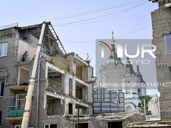 Workers are dismantling damaged structures as one of the sections of the five-storey apartment building at 44 Sobornyi Avenue that was destr...