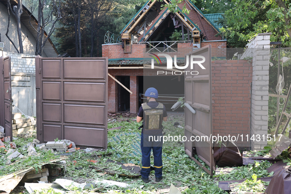 A rescuer is standing at the gate in a residential area in the city centre hit by a Russian guided bomb in Kharkiv, Ukraine, on July 24, 202...