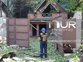 A rescuer is standing at the gate in a residential area in the city centre hit by a Russian guided bomb in Kharkiv, Ukraine, on July 24, 202...