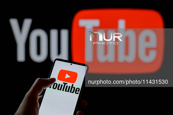 The YouTube play logo is being displayed on a smartphone, with YouTube in the background, in this photo illustration in Brussels, Belgium, o...