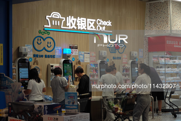 Customers are shopping at a Freshippo store in the Huangpu district of Shanghai, China, on July 25, 2024. 